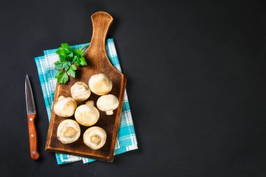 Beyaz taze petrol bir gri karanlık tabloda ahşap bir gemide maydanoz ile. Mantar. Uzay kopyalayın. Üstten Görünüm