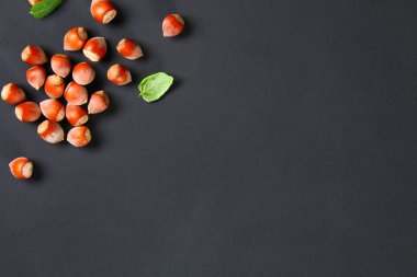 Doymuş bir siyah arka plan üzerine üstten görünüm kavrulmuş soyulmuş fındık. Abur cubur. Kopya alanı