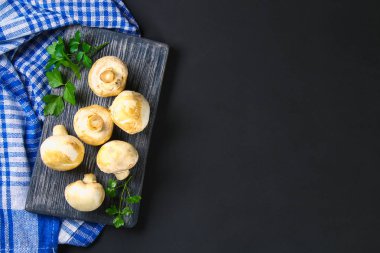 Beyaz taze petrol bir gri karanlık tabloda ahşap bir gemide maydanoz ile. Mantar. Uzay kopyalayın. Üstten Görünüm
