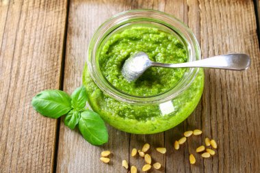 Ev yapımı pesto sos. Malzemeler. Peynir, sarımsak, fesleğen, çam fıstığı, zeytin yağı eski ahşap masa