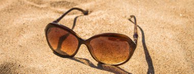 Kum üzerinde güneş güneş gözlüğü