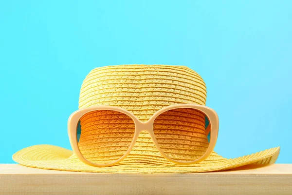 Gafas Sol Sombrero Amarillos Estante Madera Sobre Fondo Azul Pastel — Foto de Stock
