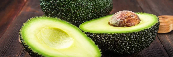 Geschnitten Und Ganze Avocado Auf Einem Holzbrett Auf Braunem Hintergrund — Stockfoto