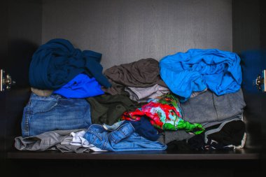 Farklı elbise yığını dolaptaki raf yalan söylüyor