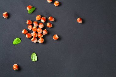 Doymuş bir siyah arka plan üzerine üstten görünüm kavrulmuş soyulmuş fındık. Abur cubur. Kopya alanı