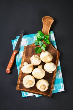 Beyaz taze petrol bir gri karanlık tabloda ahşap bir gemide maydanoz ile. Mantar. Uzay kopyalayın. Üstten Görünüm