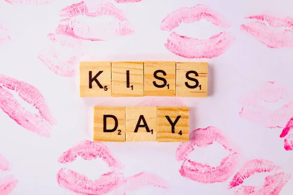 Concept for the International Day of Kisses. Lip prints on paper and text Happy day kisses