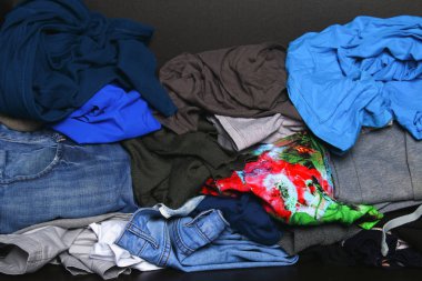 Farklı elbise yığını dolaptaki raf yalan söylüyor