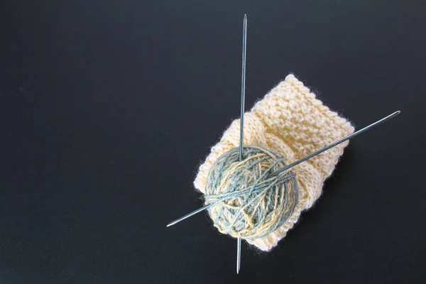 在灰色桌上织针和袜子的羊毛球 — 图库照片
