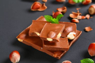 Çikolata fındık, nane ve koyu gri masada kahve taneleri