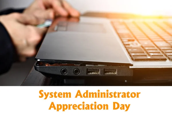 System Administrator Appreciation Day. Postcard for the holiday. The guy is fixing the laptop