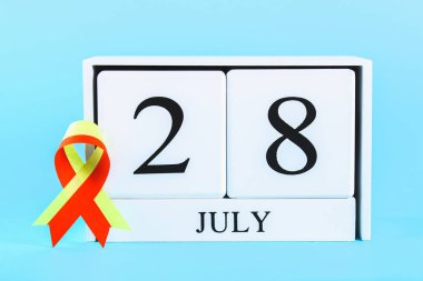 Dünya hepatit günü. Haziran 28 üzerinde mavi bir tablo gösteren bir ahşap beyaz takvim. Kırmızı Sarı kurdele