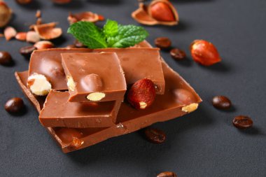 Çikolata fındık, nane ve koyu gri masada kahve taneleri