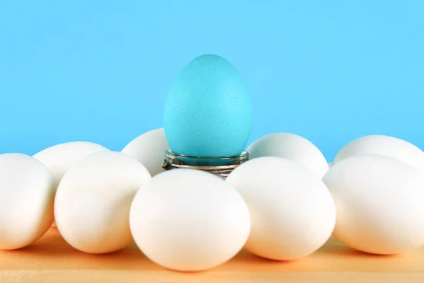 Modré Vajíčko Vyhrál Mezi Bílé Vejce Dřevěný Stůl — Stock fotografie