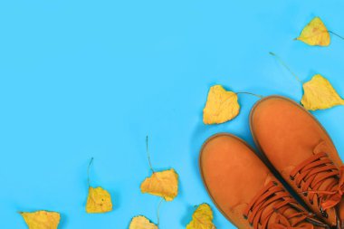 Turuncu kahverengi erkek sonbahar bir mavi pastel arka plan üzerinde botlar. Üstten görünüm, kopya alanı