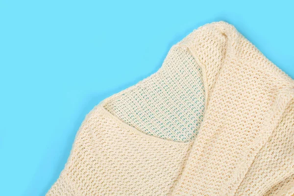 Beyaz yün giyim kadar kapatın. Üstten görünüm. Pastel mavi tablo yüzey arka plan. Kopya alanı