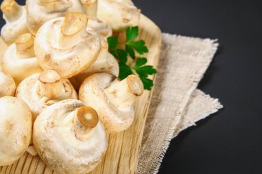 Beyaz taze petrol bir gri karanlık tabloda ahşap bir gemide maydanoz ile. Mantar. Uzay kopyalayın. Üstten Görünüm