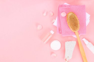 Banyo aksesuarları pastel pembe bir arka plan üzerinde. Görünümü en çok, uzay kopyalayın. Fırça, lif kabağı, havlu, losyon, krem peni