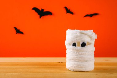 Cadılar Bayramı için kavram. Yarasalar ve mumya bir kavanoz, bandaj ve turuncu bir arka plan üzerinde mum