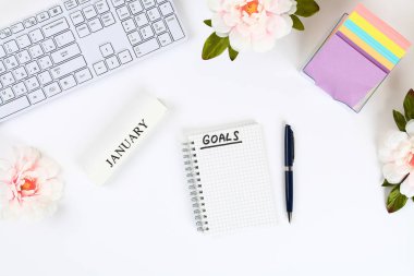 Write a goal for the new year 2010 in a white notebook on a white desktop next to a coffee mug and a keyboard. Top view, flat layout clipart