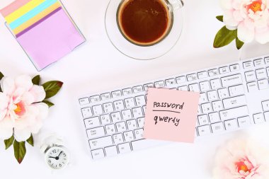 Kahve kupa ve klavye yanında beyaz masaüstündeki bir Not etiket üzerinde paroladır. Üstten görünüm, düz düzen