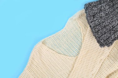 Beyaz yün giyim kadar kapatın. Üstten görünüm. Pastel mavi tablo yüzey arka plan. Kopya alanı