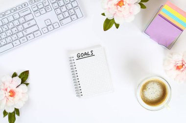 Bir hedef için yeni yıl 2010 beyaz bir defterde bir kupa kahve ve bir klavye yanında beyaz bir masaüstü yazın. Üstten görünüm, düz düzen