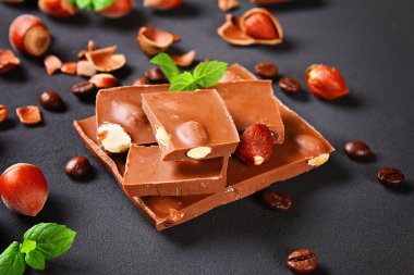 Çikolata fındık, nane ve koyu gri masada kahve taneleri