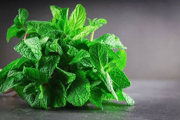 A bunch of mint tied with twine on a gray background.