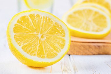 Bir cam kabı ve bir sürahi soğuk limonata limon tarafından çevrili beyaz ahşap zemin üzerinde