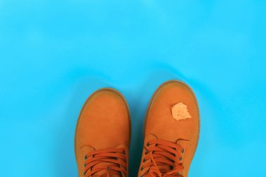 Turuncu kahverengi erkek sonbahar bir mavi pastel arka plan üzerinde botlar. Üstten görünüm, kopya alanı