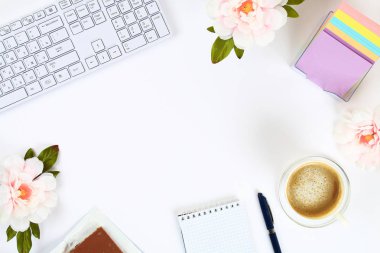 Boş bir beyaz Not defteri bir kupa kahve ve bir klavye yanında beyaz bir masaüstü. Üstten görünüm, düz düzen. Kopyalama alanı