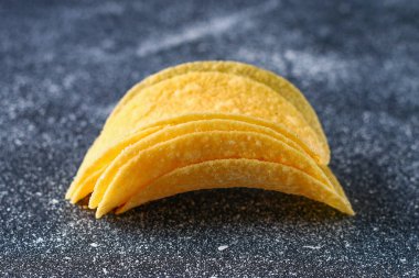 Bir yığın bir gri karanlık tabloda gevrek cipsi. Aperatif