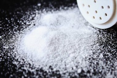 Slaytlar tuz kristallerinin küçük siyah bir tablo üzerinde dağılmış