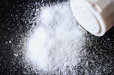 Slaytlar tuz kristallerinin küçük siyah bir tablo üzerinde dağılmış
