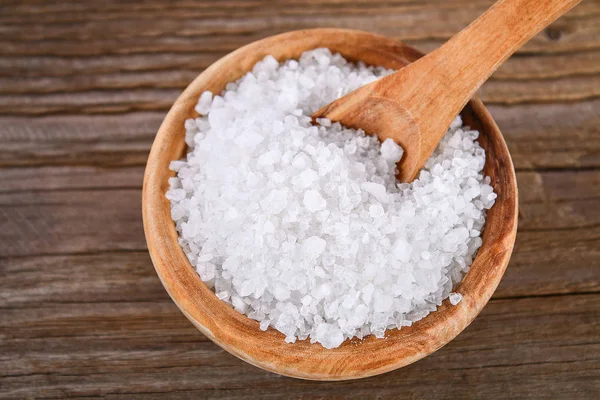 在一个木碗和勺子在桌子上的大海盐的晶体 广告盐的背景 咸食品 — 图库照片
