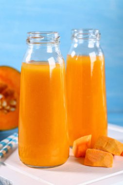 Şişelenmiş kabak güler yüzlü. Kabak suyu mavi bir tablo. Sonbahar içecekler