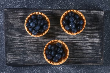 Bir tablo üzerinde kum tartlets mavi karaçalı meyveleri