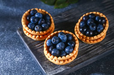 Bir tablo üzerinde kum tartlets mavi karaçalı meyveleri