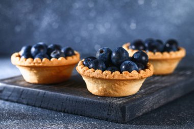 Bir tablo üzerinde kum tartlets mavi karaçalı meyveleri