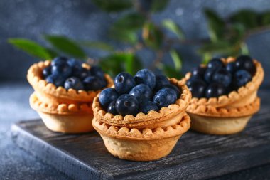 Bir tablo üzerinde kum tartlets mavi karaçalı meyveleri