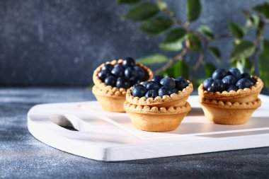 Bir tablo üzerinde kum tartlets mavi karaçalı meyveleri