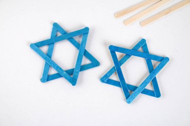DIY. Hanuka dekor. Davut'un Yıldızı dondurma gelen beyaz ahşap bir masa üzerinde sopa. Kılavuz, resmi için adım. Hanuka üzerinde DIY.