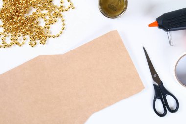 DIY altın Noel ağacından boncuk garland. Resmi için karton, yıldız, sıcak tutkal ve boncuk kendi elleriyle dekoratif bir Noel ağacı yapmak nasıl Kılavuzu. El yapımı. Masada üstten görünüm.