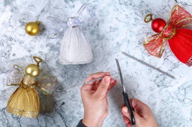 DIY melek plastik şişe. Fotoğrafta bir şişe, kendinden yapışkanlı parlak kağıt, şerit ve kendi elleriyle bir Noel top dekoratif bir melek yapmak nasıl Kılavuzu. El yapımı. Üstten görünüm. Adım adım.