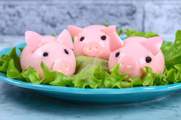 Diy pig from eggs. Workshop how to make a pig from a boiled egg painted in broth beets stuffed with stuffing. Appetizer on Christmas or New Year table. Top view. Creative decorative food for kid. Pig.