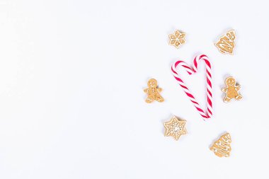 Noel düzeni. Çizgili kırmızı-beyaz baston şekerler ve beyaz zemin üzerine ev yapımı zencefilli kurabiye. Yeni yıl 2019, Yeniyıl, kış konsepti. Kopyalama alanı, tov görünümü, düz yatıyordu kompozisyon