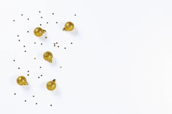 Christmas layout. Golden confetti in the form of stars and toys balls on the Christmas tree on a white background. New Year 2019, christmas, winter concept. Copy space, tov view, flat lay composition