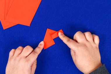 Mavi arka plan DIY Çince Ejderha. Hediye fikirleri, dekor Çin yeni yılı. El yapımı kırmızı altın ay ejderha aslandan Modüler origami. Adım adım. El sanatları işlemidir. Üstten görünüm.