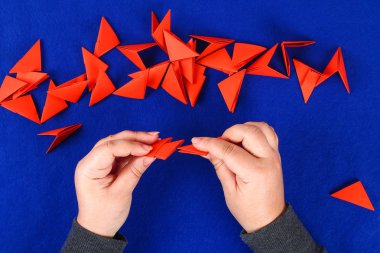 Mavi arka plan DIY Çince Ejderha. Hediye fikirleri, dekor Çin yeni yılı. El yapımı kırmızı altın ay ejderha aslandan Modüler origami. Adım adım. El sanatları işlemidir. Üstten görünüm.